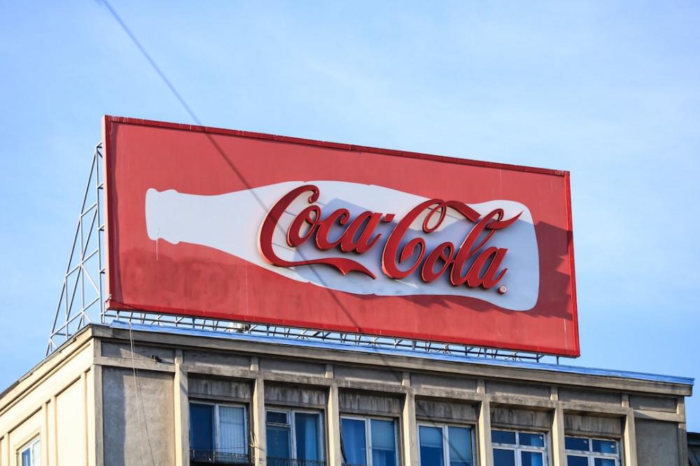 Coka-Cola on red billboard sign regarding paid advertising sample